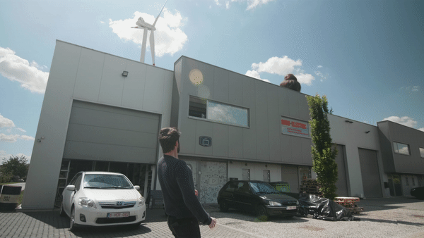 Tymon as a giant behind a building.